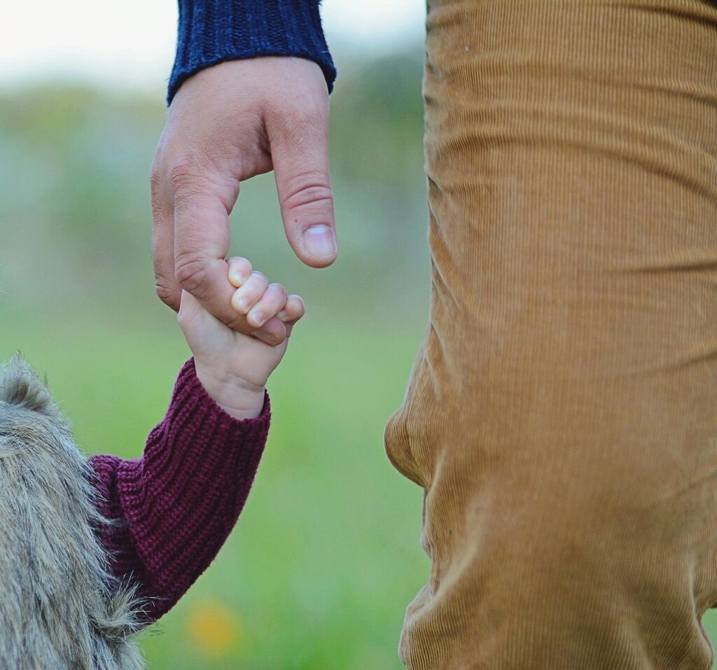 Child holding the land of father
